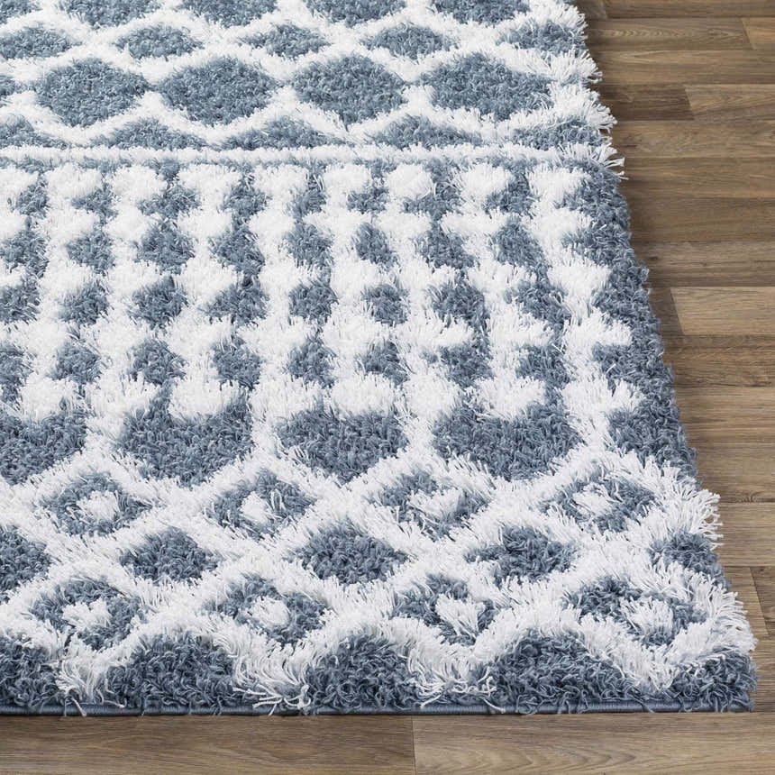 Close-up of a denim and white Camp Shag Area Rug with a geometric pattern and shaggy texture. Front