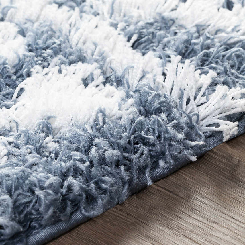 Close-up of the Camp Shag Area Rug in denim and white, showing the rug's shaggy texture and machine-woven construction. Texture