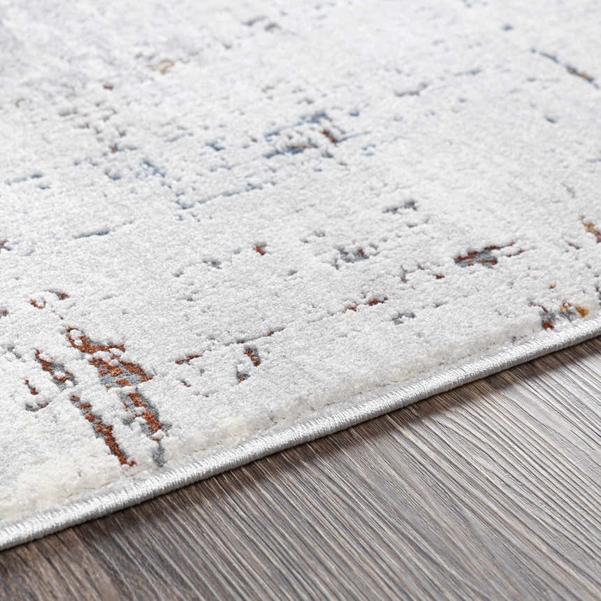 Close-up of Concordia Faux Silk Rug showing off-white, gray, and burnt orange abstract pattern and soft texture. Texture