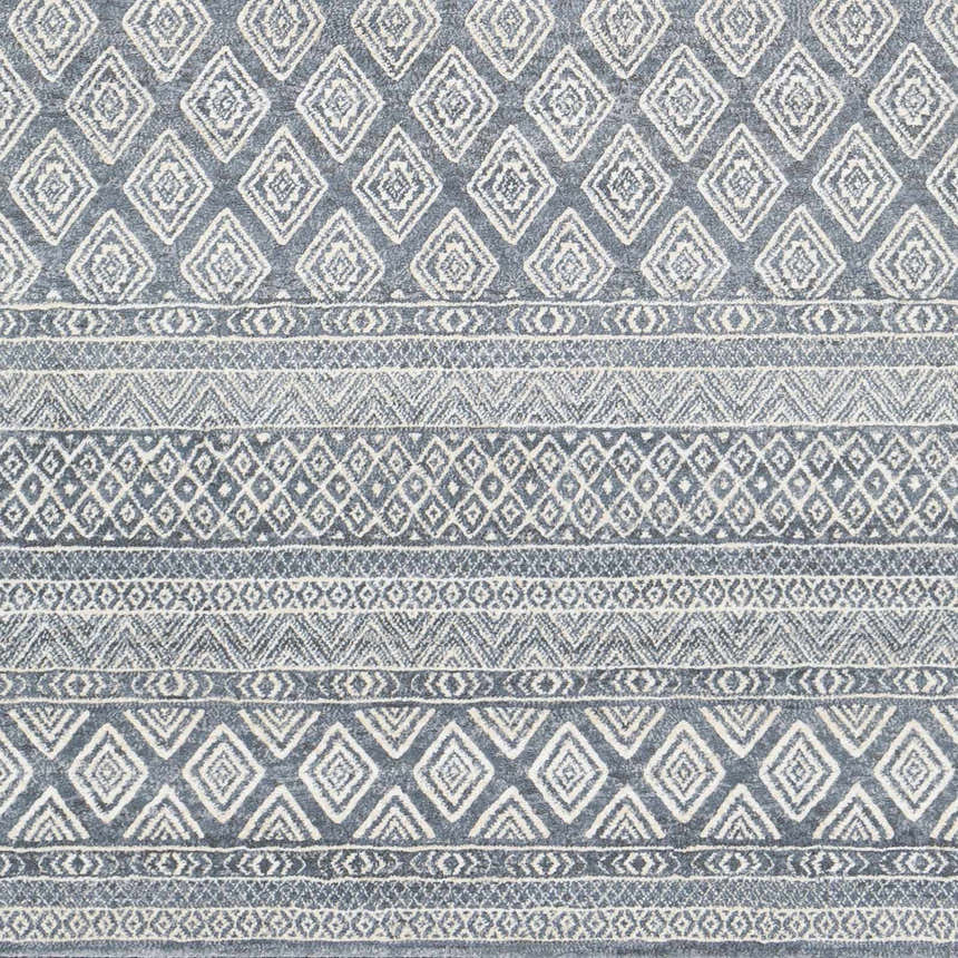 Close-up of Centertown Area Rug. Blue, charcoal, and ivory geometric diamond and stripe pattern. Swatch