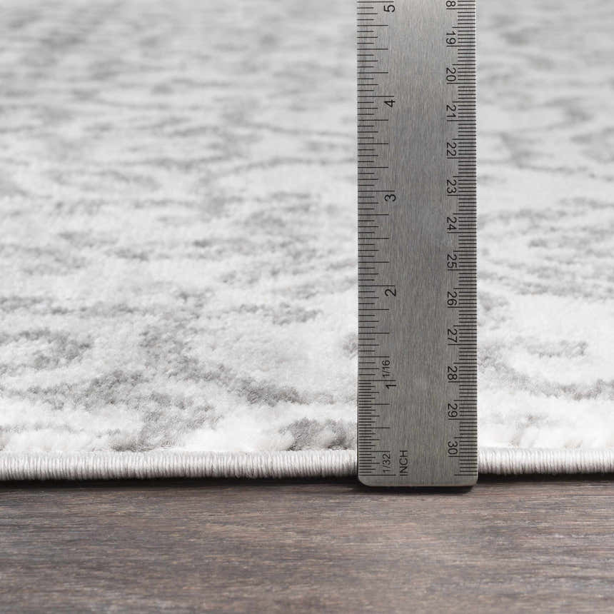 Close-up of the Cordele Area Rug, a clearance item, showing its gray and white traditional pattern and texture. Pile