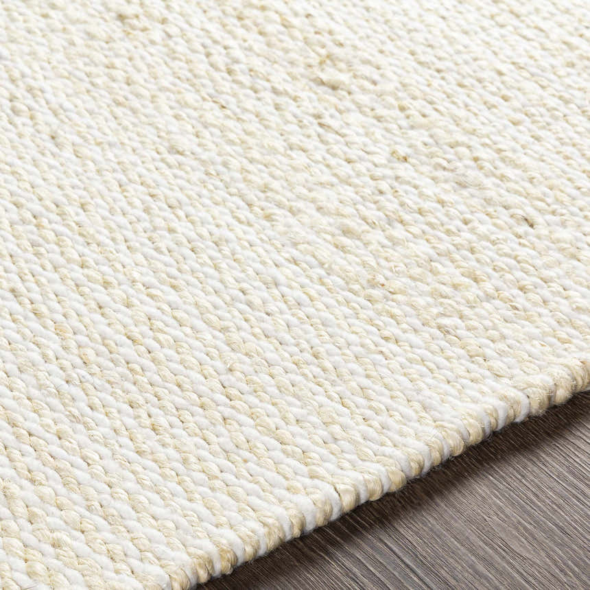 Close-up of the hand-woven Cople Area Rug. Cream and off-white jute rug with a textured, contemporary design. Texture