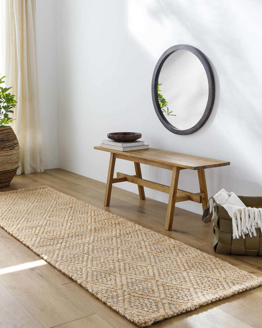 Entryway with Buwoi Hand Woven Tan Jute Rug, wood bench, round mirror, woven basket, and light wood floors. Roomscene-Runner