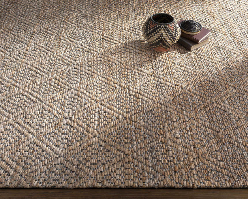 Close-up of the hand woven Buwoi Tan Jute Rug, showcasing its natural jute texture and subtle geometric pattern. Styleshot