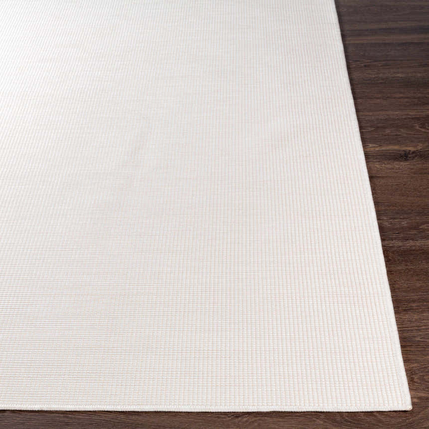 Close-up of the cream Currimundi Area Rug showing its subtle woven texture on a dark wood floor. Front