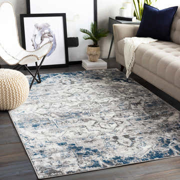 Living room scene with blue and gray Carrington Area Rug, sofa, chair, and modern art. Roomscene-Rectangle