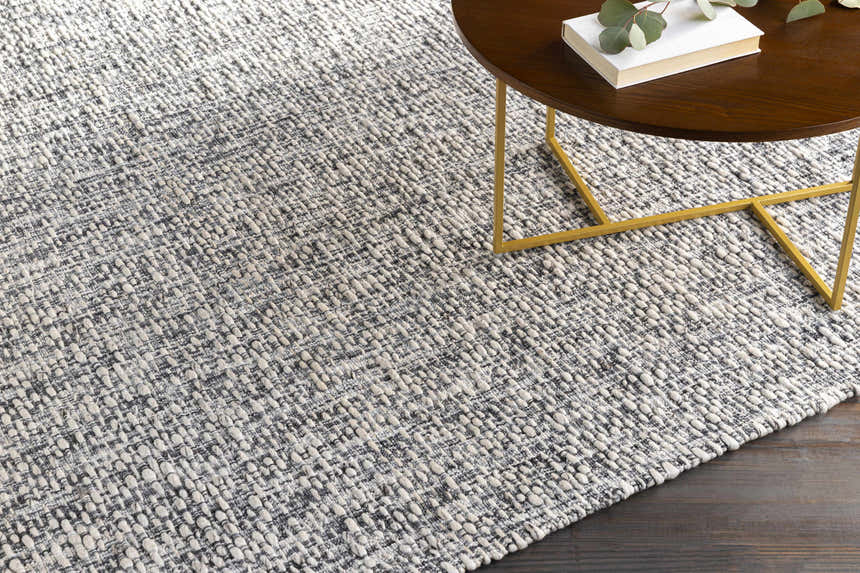 Close-up of the hand-loomed Cushendall Premium Rug. Dark blue and off-white contemporary rug with a textured design. Styleshot