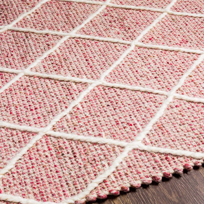 Close up of the Dacudao Area Rug showing the cream geometric pattern on a burgundy and dusty pink wool weave. Texture