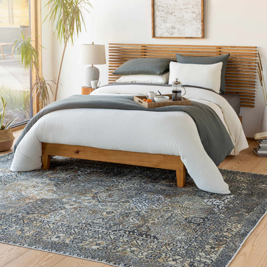 Bedroom scene with a beige, black, and gray Dagatan Washable Area Rug under a wood bed frame. Roomscene-Rectangle