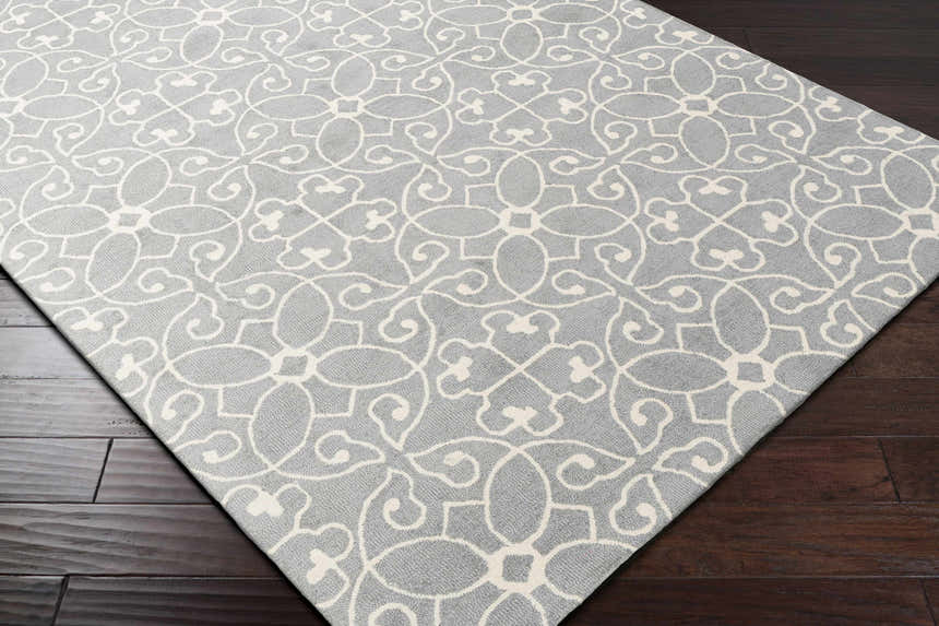 Close up of the Davie Area Rug. Slate blue wool rug with an ivory, traditional floral pattern. Corner