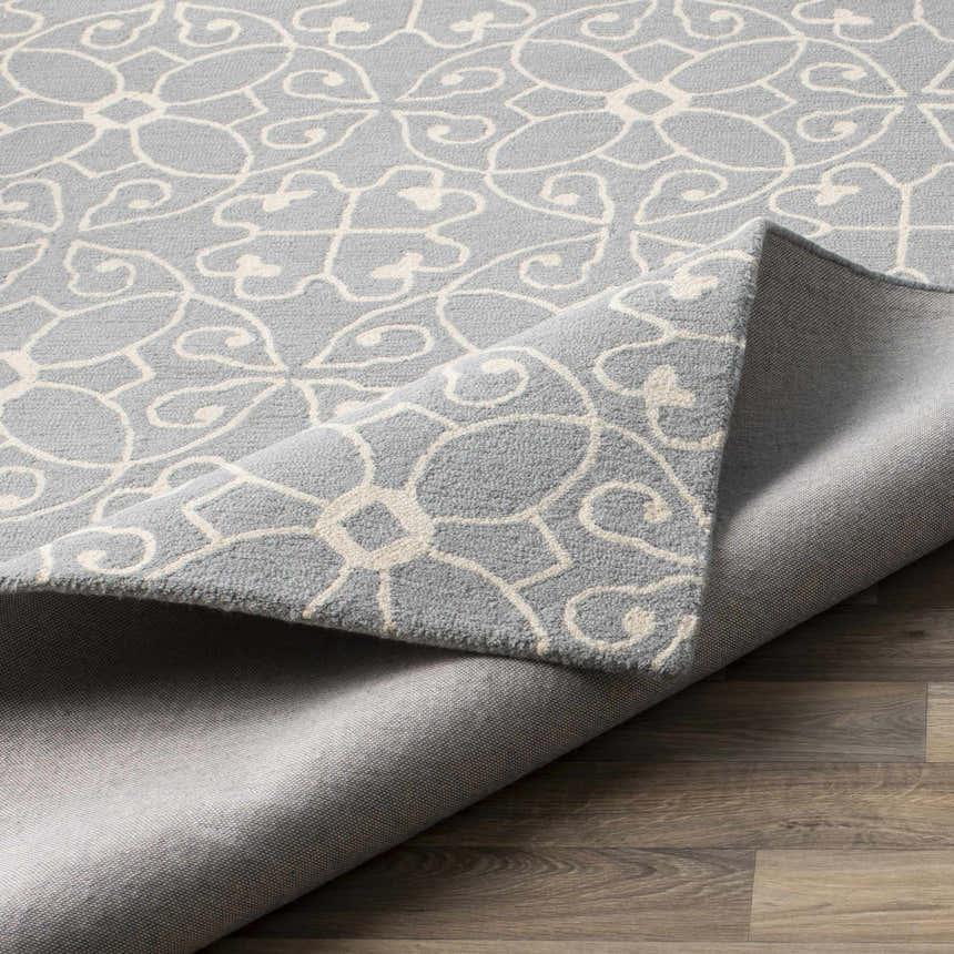 Close-up of the Davie Area Rug, a hand-tufted wool runner in ivory and slate blue with a traditional floral pattern. Fold