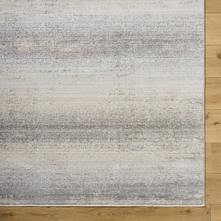 Close-up of the Uzima Gray Area Rug showing its contemporary gray, slate, and cream horizontal pattern and soft texture. Corner