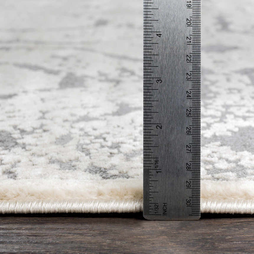 Close-up of Frenchtown Area Rug showing pile height with ruler. Neutral gray and white abstract pattern. Clearance rug. Pile