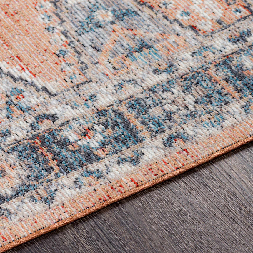 Close-up of Fullarton Performance Rug showing beige, blue, and red tones in a distressed, traditional pattern. Texture