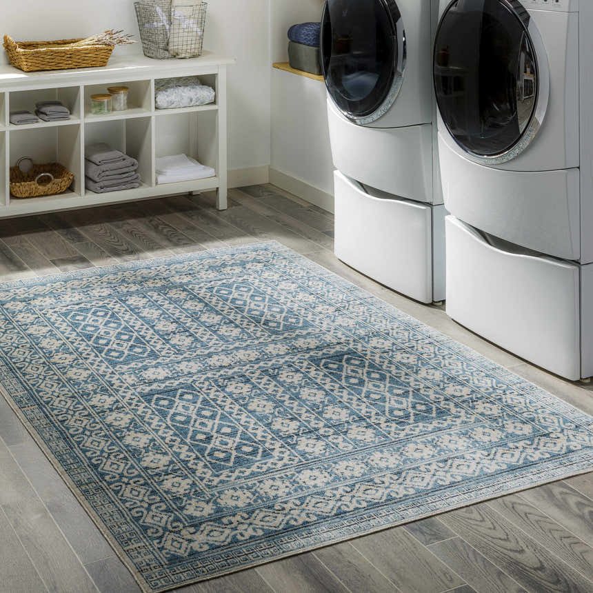 Laundry room scene with white washer/dryer and blue and cream Gandy Washable Area Rug. Roomscene-Rectangle