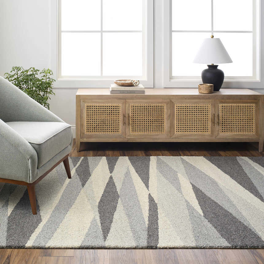Living room scene with gray armchair and Garlands Area Rug in black, charcoal, and gray geometric pattern. Roomscene-Rectangle