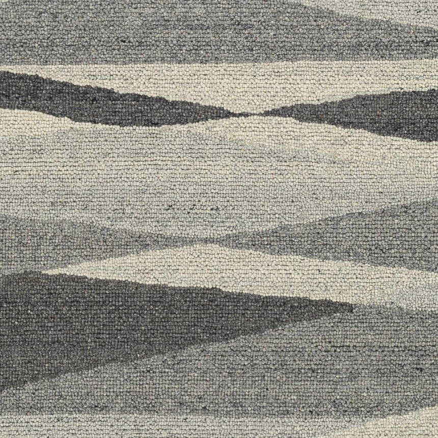 Close-up of the Garlands Area Rug. Hand-tufted wool rug with a contemporary, abstract stripe pattern in black, charcoal, and gray tones. Swatch