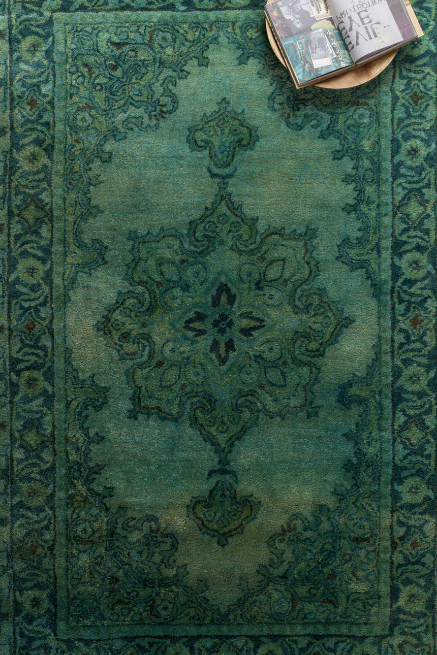 Close-up of the Gilbertsville Area Rug. Features a traditional oriental pattern in dusty sage, emerald, and olive hues. Styleshot