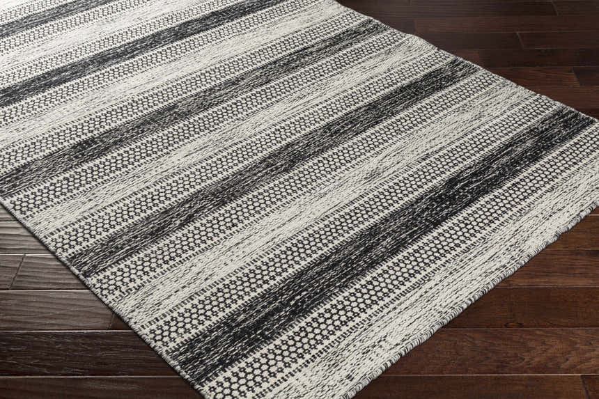 Close up of the Glengary Area Rug in black and ivory with a striped, geometric pattern. Hand woven texture. Corner