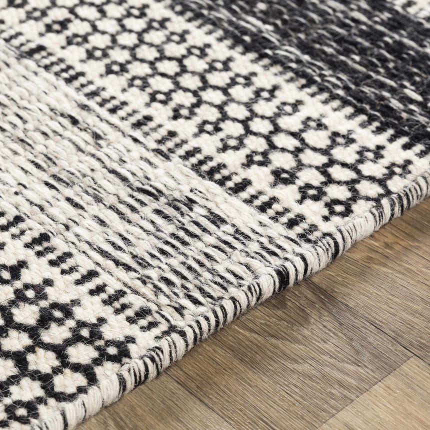 Close-up of the hand woven Glengary Area Rug. Black and ivory rug with geometric patterns and textured weave. Texture
