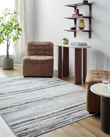 Living room scene with Weber Gray Area Rug, brown leather chair and ottoman, and marble side table. Roomscene-Rectangle