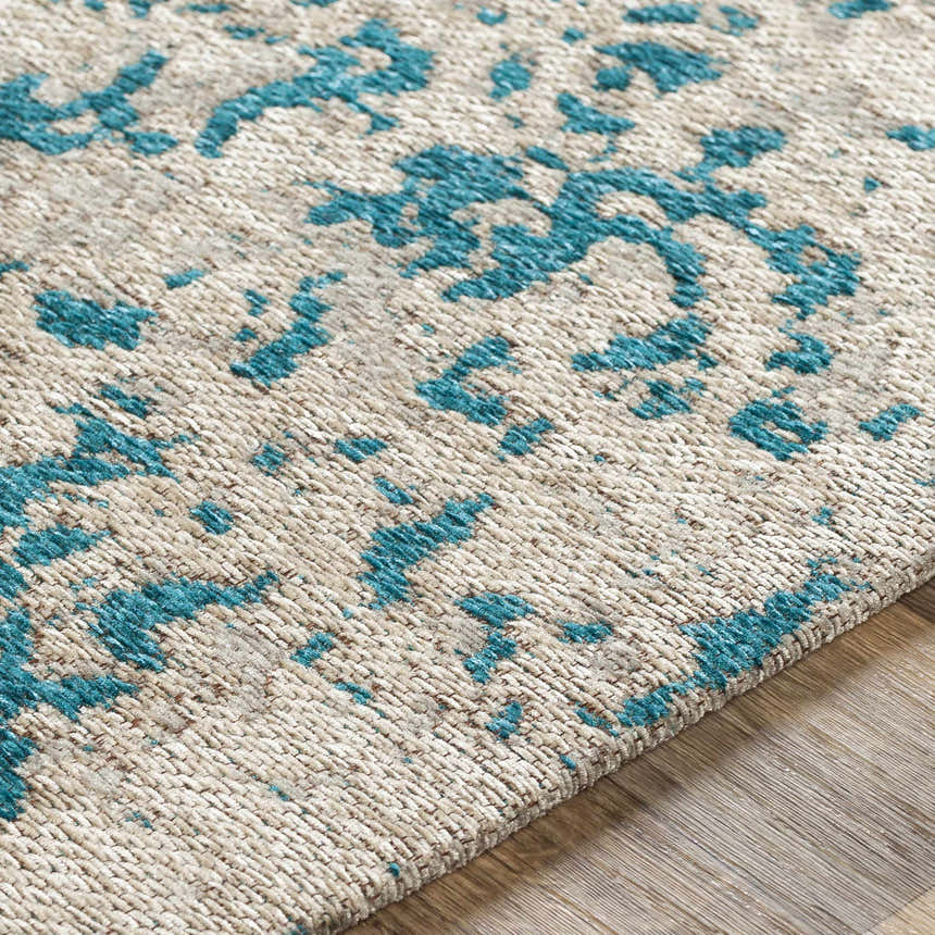 Close-up of the Sweeny Beige/Blue Abstract Area Rug showing its woven texture and teal, beige, and ivory abstract pattern. Texture