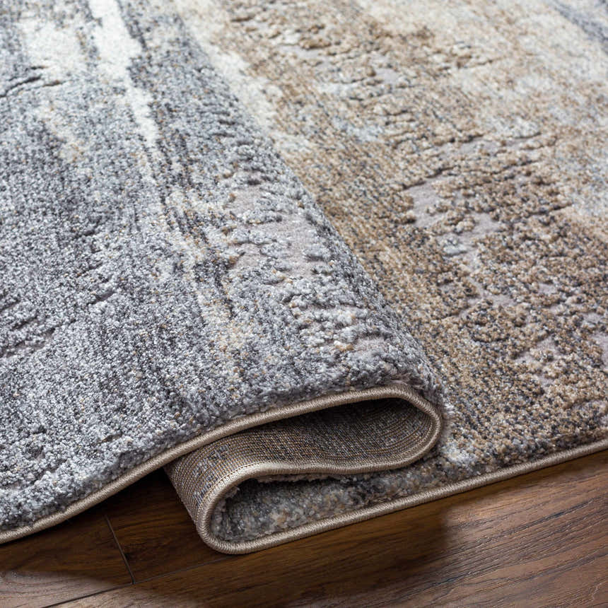 Close-up of the Gonen Thick Luxe Rug showing its gray, brown, and cream abstract pattern and plush, textured pile. Fold