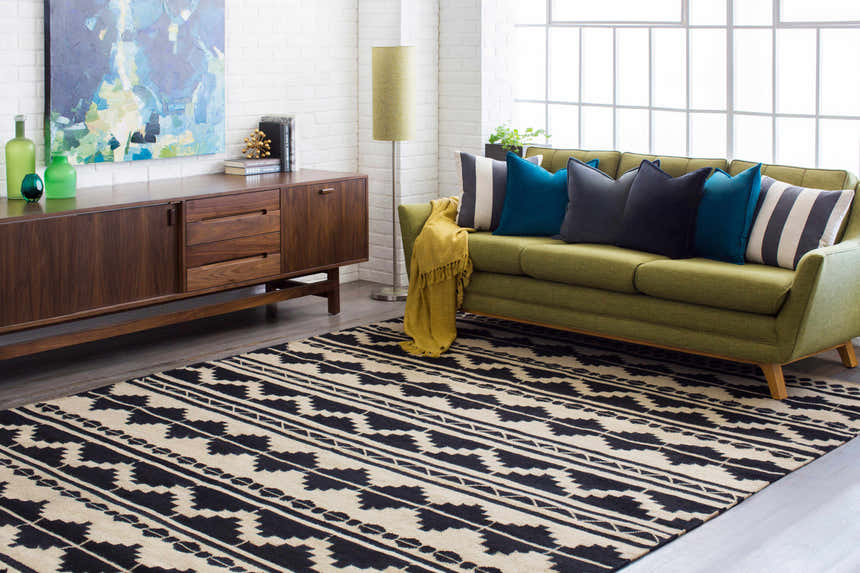 Living room scene with a black and gray geometric Gratiot Area Rug, green sofa, and mid-century modern furniture. Roomscene-Rectangle
