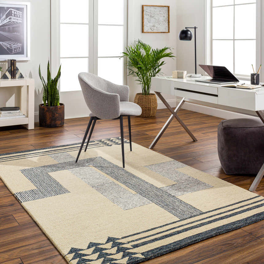 Home office with beige Guta Area Rug, modern desk, gray chair, and wood floors. Contemporary, Scandinavian style. Roomscene-Rectangle