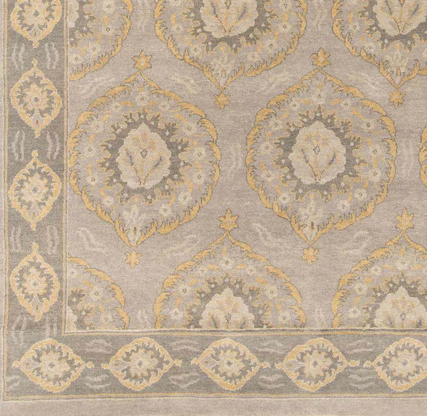 Close-up of the Haleiwa Clearance Rug, a hand-knotted wool rug with a traditional camel and taupe floral medallion pattern. Swatch