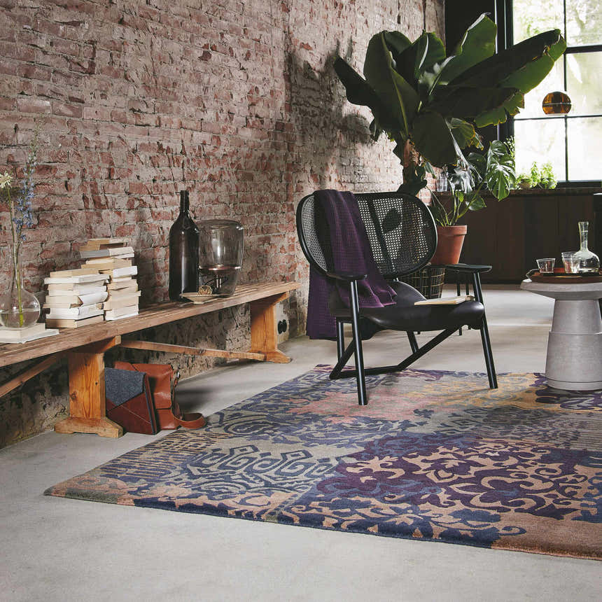 Loft room scene with brick wall, Hallsboro Area Rug in charcoal, brown, gray tones, chair, and books. Roomscene-Rectangle