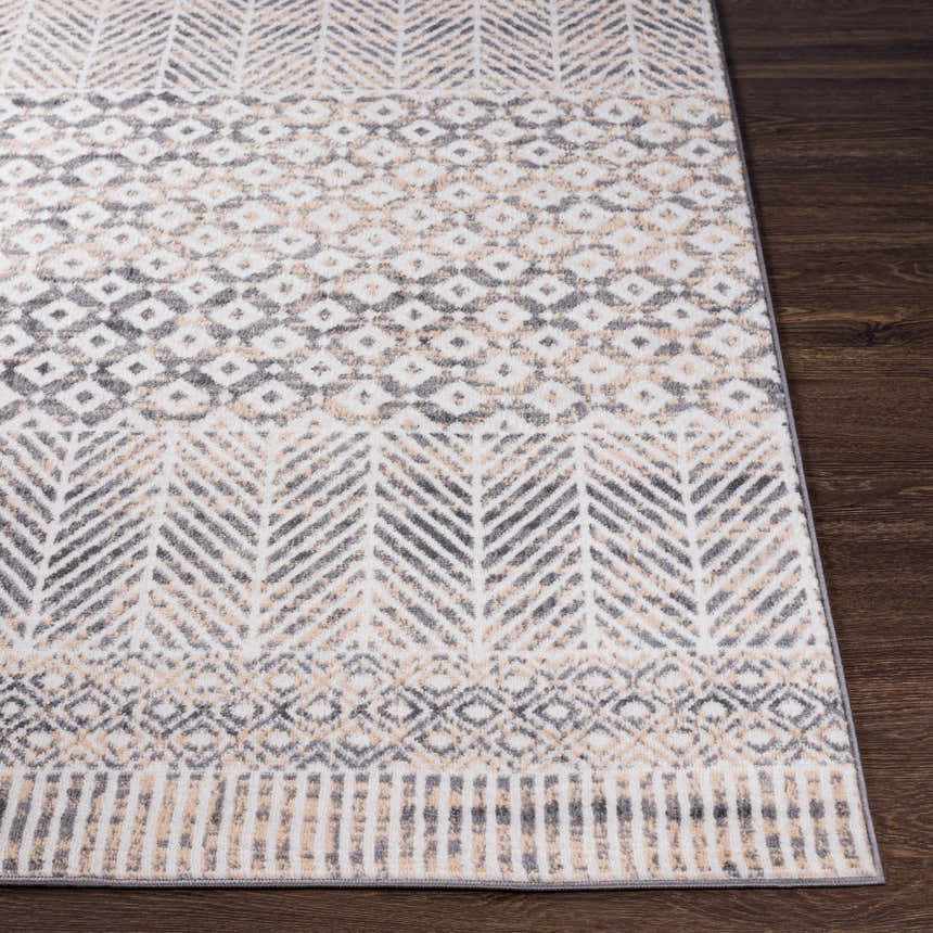Close-up of Hassocks Area Rug showcasing charcoal, cream, and tan geometric patterns on a soft, textured weave. Front