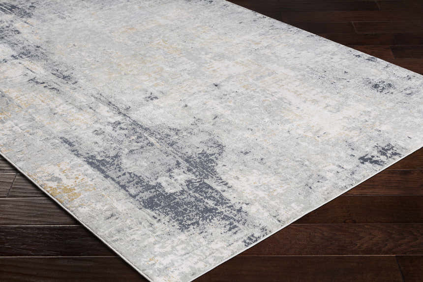 Close-up of the Hayle Area Rug, featuring charcoal, gray, and mustard hues in a contemporary abstract pattern. Corner