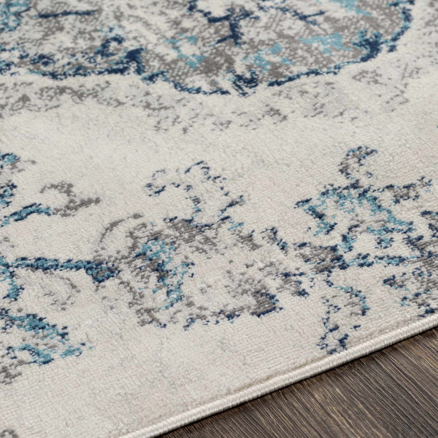 Close-up of Holmwood Area Carpet showing cream, gray, and light blue bohemian floral pattern and machine-woven texture. Texture