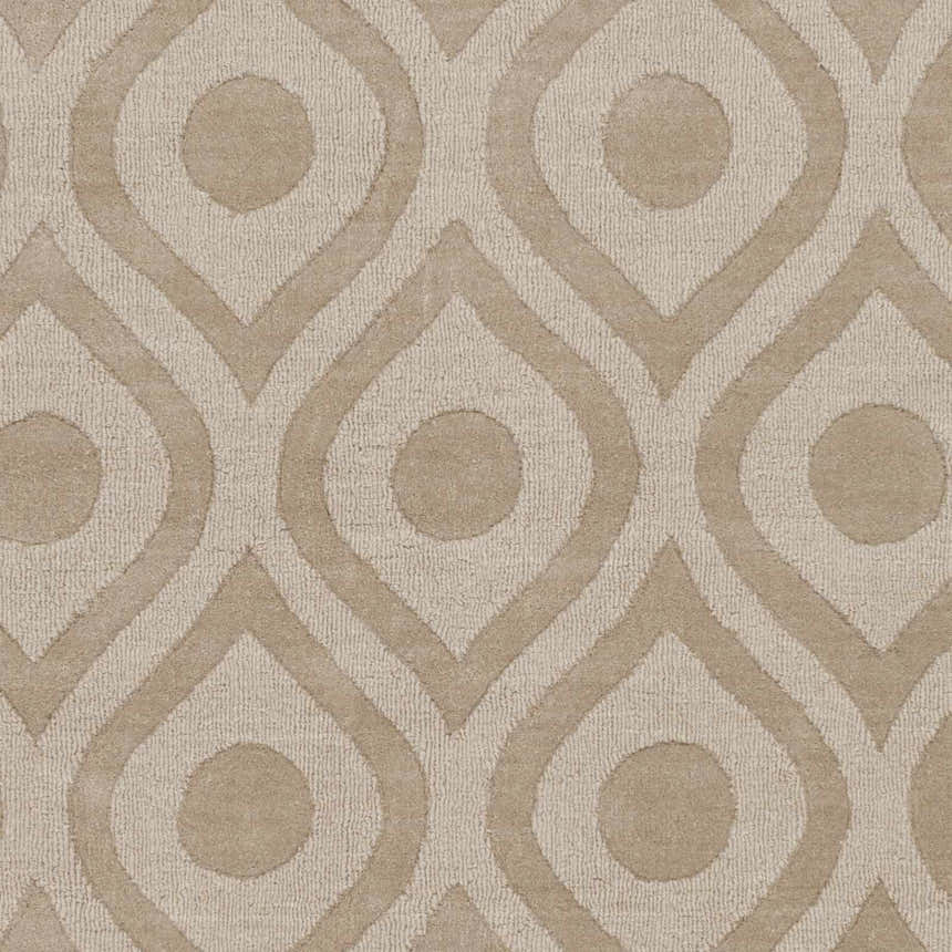 Close-up of the Hundred Area Rug showing its tan, hand-loomed wool with a contemporary teardrop and circle pattern. Swatch