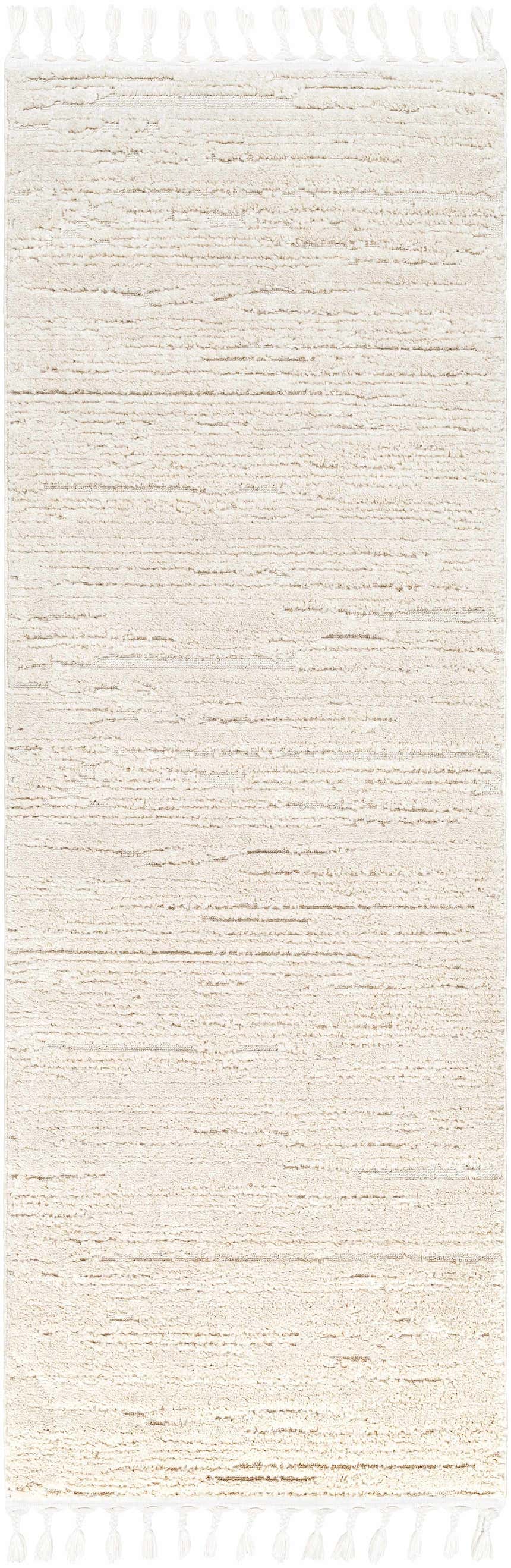 Close-up of the Ibarra Textured Ivory High/Low Pile Rug with Tassels showing its texture and tassel details. Design-Runner-2773