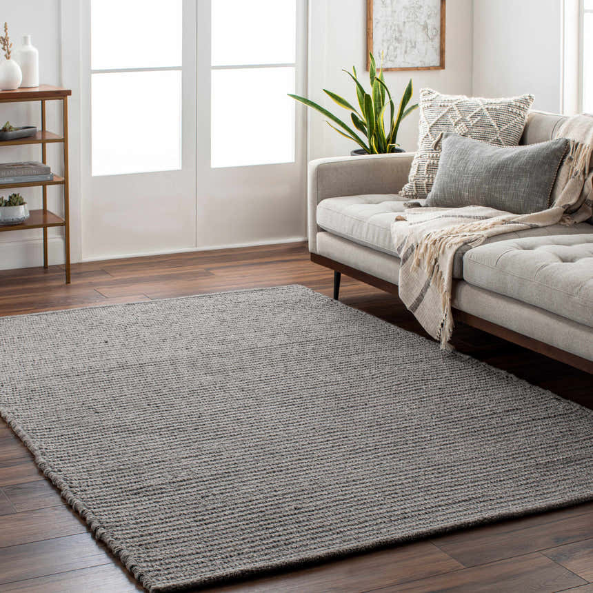 Living room scene with gray Innisfail Area Rug, beige sofa, wood floors, and neutral decor. Contemporary style. Roomscene-Rectangle