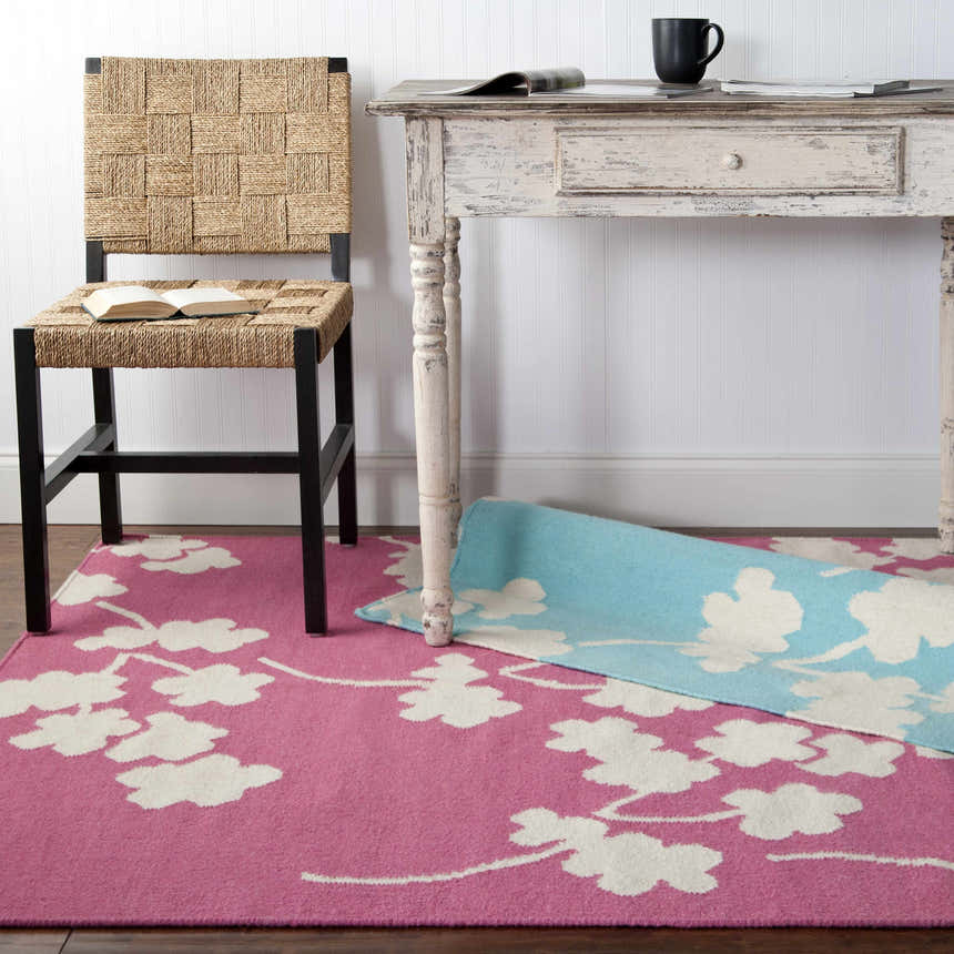 Cozy room scene with a rose Johnstown Area Carpet, woven chair, and distressed white desk. Contemporary style. Styleshot
