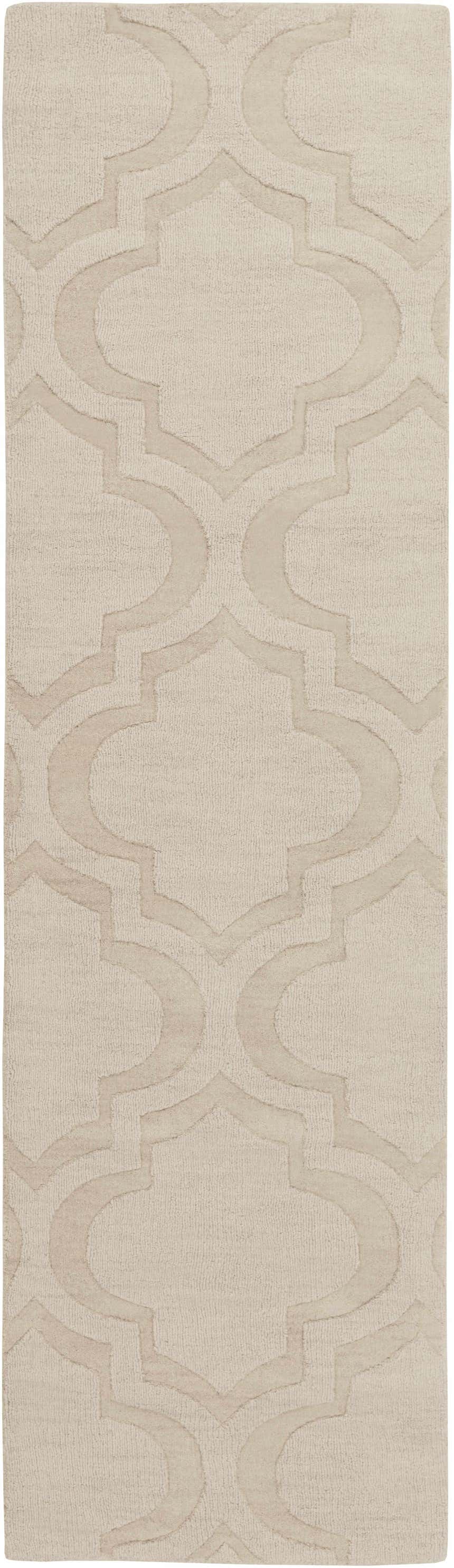 Close up of the tan Kake Carpet, a hand-loomed wool rug with a raised geometric trellis pattern. Design-Runner-38