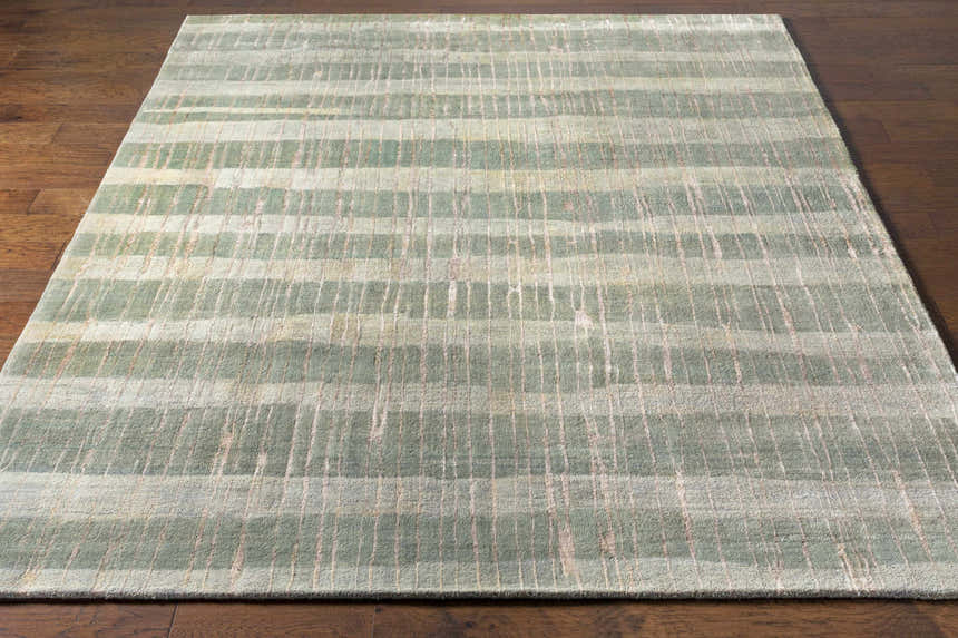 Close-up of the Kalaheo Premium Rug. Sage green wool rug with a contemporary striped pattern on a hardwood floor. Front