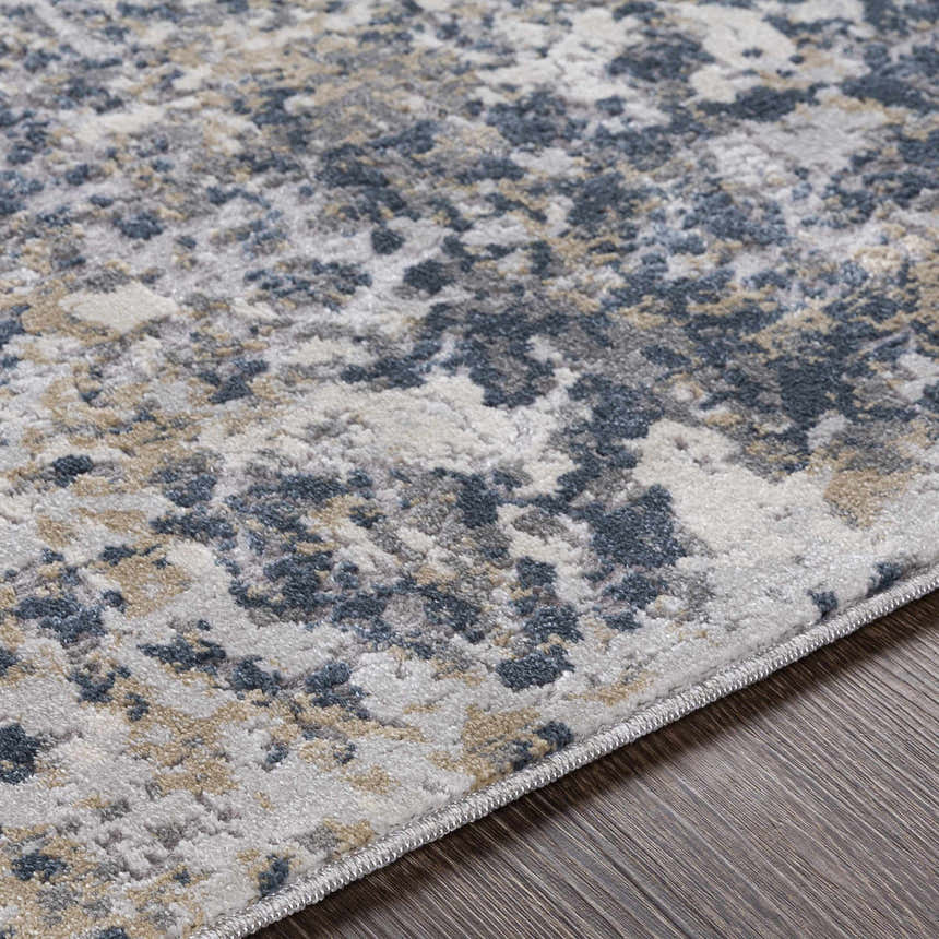 Close-up of the Kanahooka Area Rug showing its contemporary charcoal, blue, beige, and gray abstract pattern and soft texture. Texture