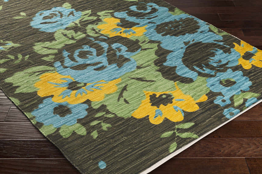 Close-up of the Kanosh Carpet; a hand-woven, 100% cotton rug with a contemporary floral design in aqua, green, saffron, and yellow. Corner