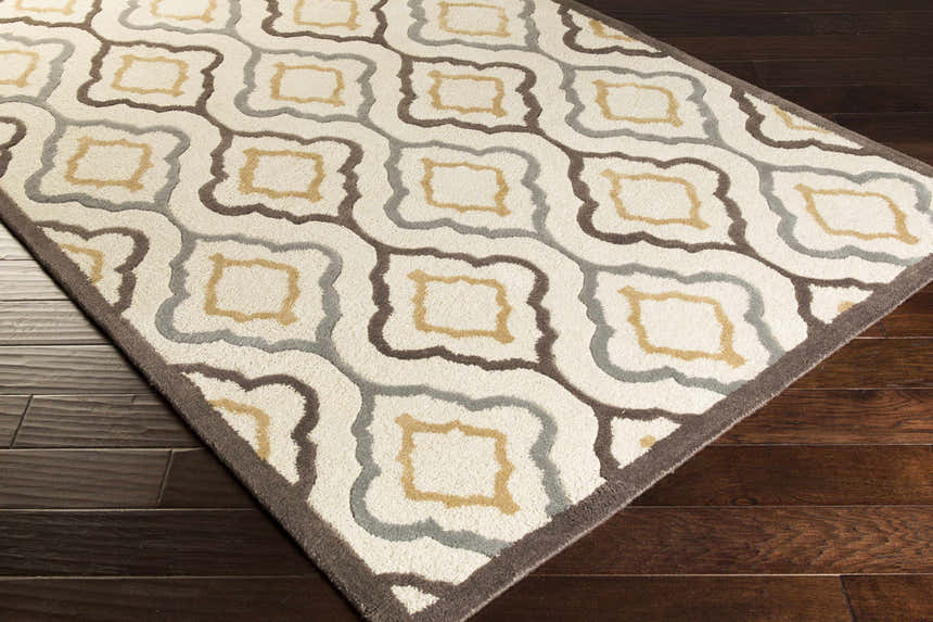 Close-up of the Karval Clearance Rug. Hand-tufted wool rug with a geometric trellis pattern in ivory, tan, gray, and brown. Corner