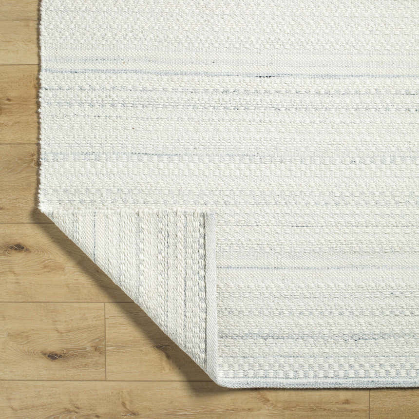 Close up of the hand woven Kendi Light Slate Area Rug, cream and light slate wool texture. Fold