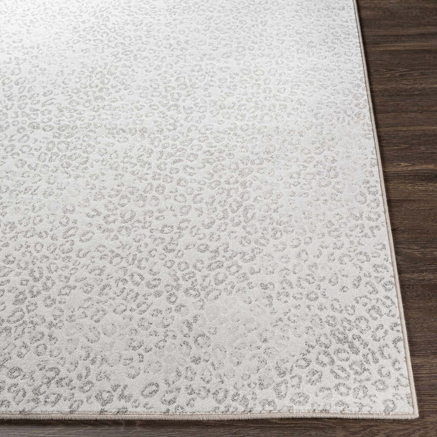 Close-up of the Keenes Leopard Print Area Rug showing its charcoal and cream animal pattern and machine woven texture. Front