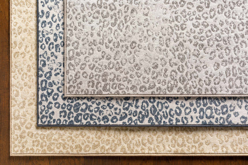 Close-up of Keenes Leopard Print Area Rug in charcoal, cream, and light gray colors and animal print pattern. Styleshot