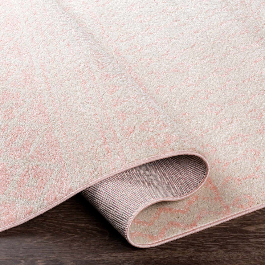 Close-up of the Constantin Blush Area Rug showing the blush and light gray pattern and machine-woven texture. Fold