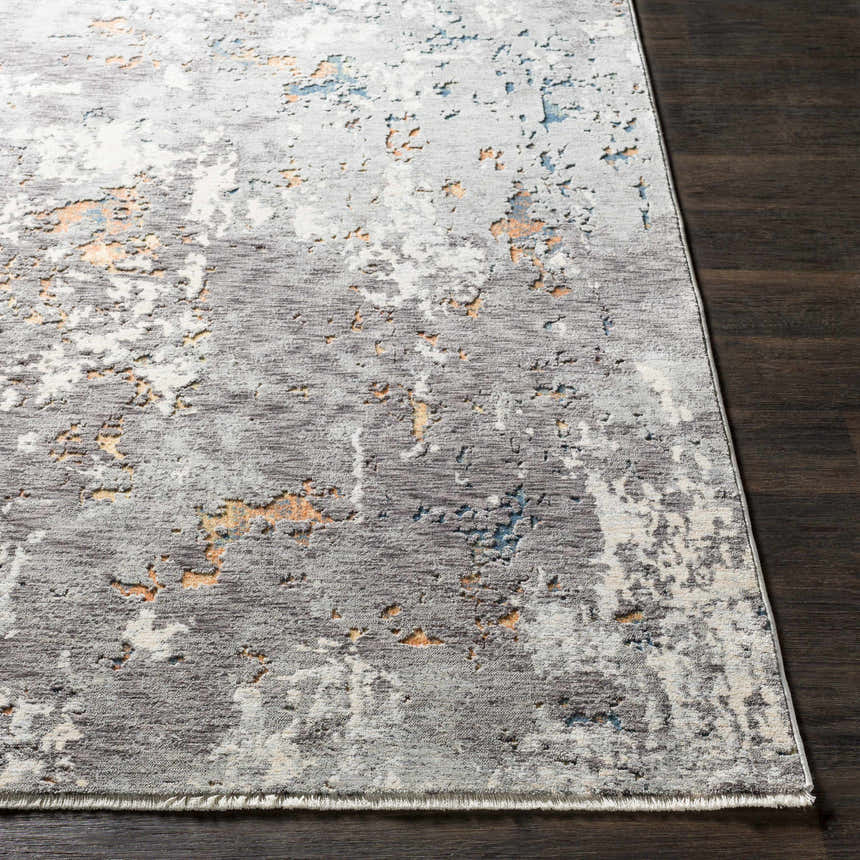Close up of Kenedy Carved Statement Carpet in blue, charcoal, and ivory on dark wood floor. Contemporary style. Front