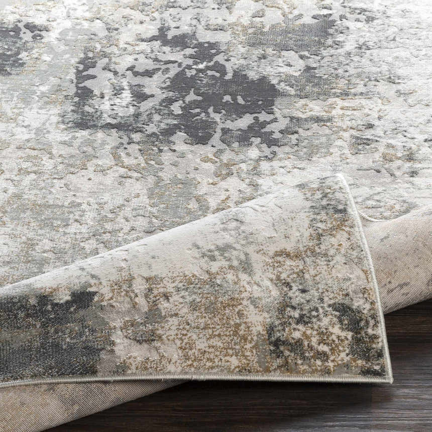 Close up of the Kiana Area Rug, a contemporary rug with gray, white, and brown abstract pattern. Fold