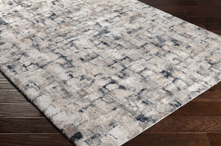 Close-up of the Kilbirnie Area Rug. Contemporary design in black, cream, gray, and beige on a textured polypropylene rug. Corner